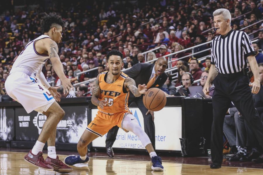 Sophomore guard Kobe Magee attempts to make a pass while Head Coach Rodney Terry calls out the play at the Battle of I-10 against the Aggies at the NMSU court. 