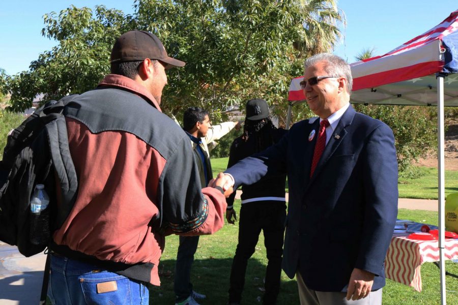 Candidate Rick Seeberger shakes hands with formal student.