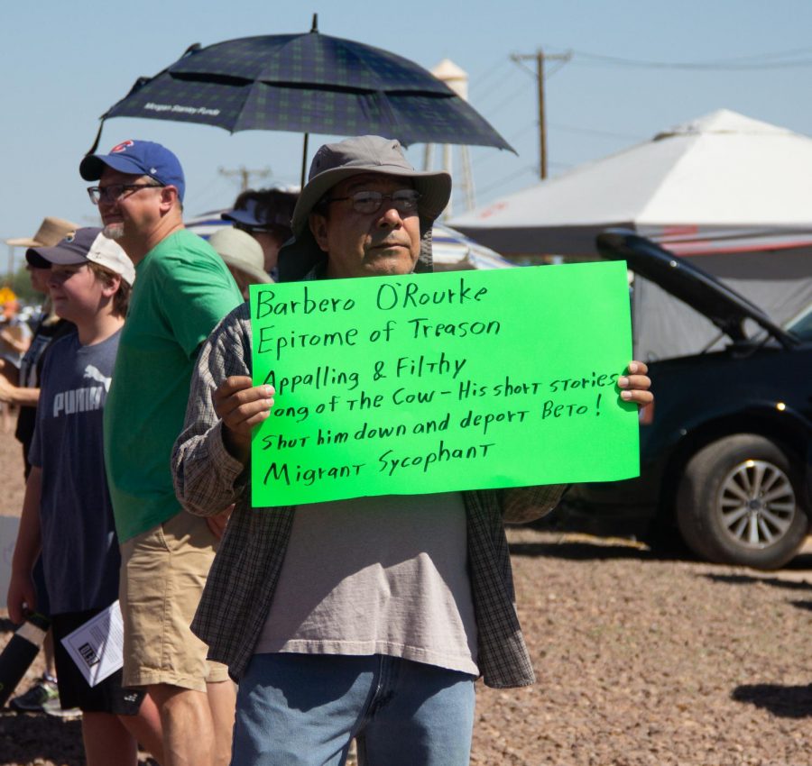 A man holds a sign listing controversial short stories and poems by Democratic presidential candidate Beto ORourke at the Clint Border Patrol Station rally held by ORourke on Sunday June 30, 2019.