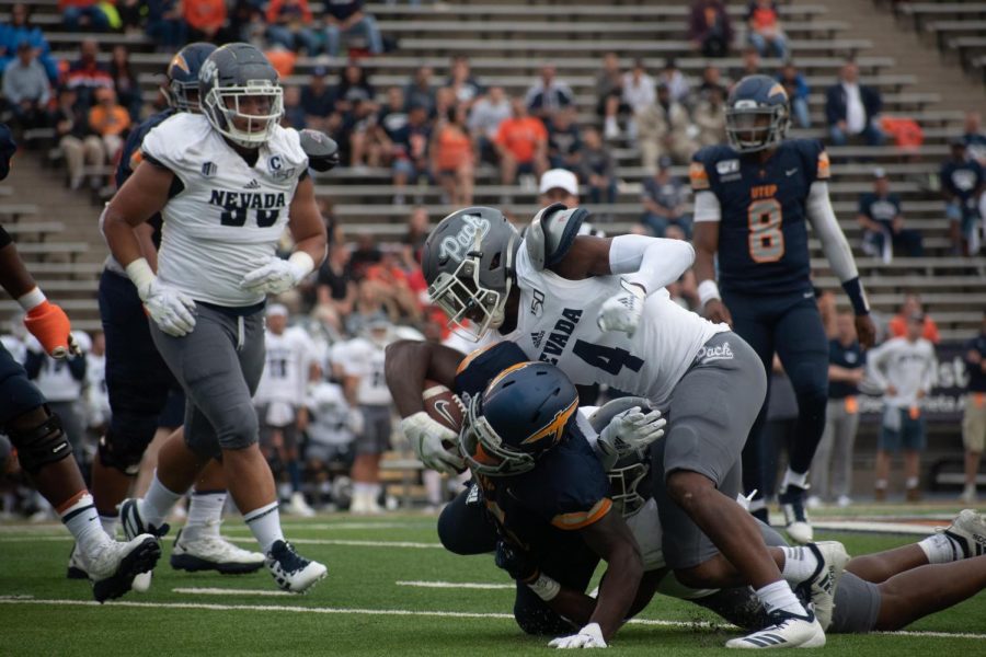 UTEP+player+Joshua+Fields+is+finally+brought+down+by+two+defenders+against+the+University+of+Nevada.