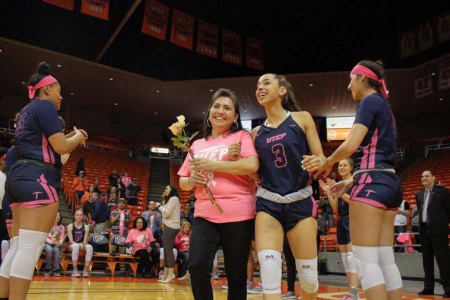 Freshman guard Katia Gallegos walks with a breast cancer survivor pregame against Charlotte. 