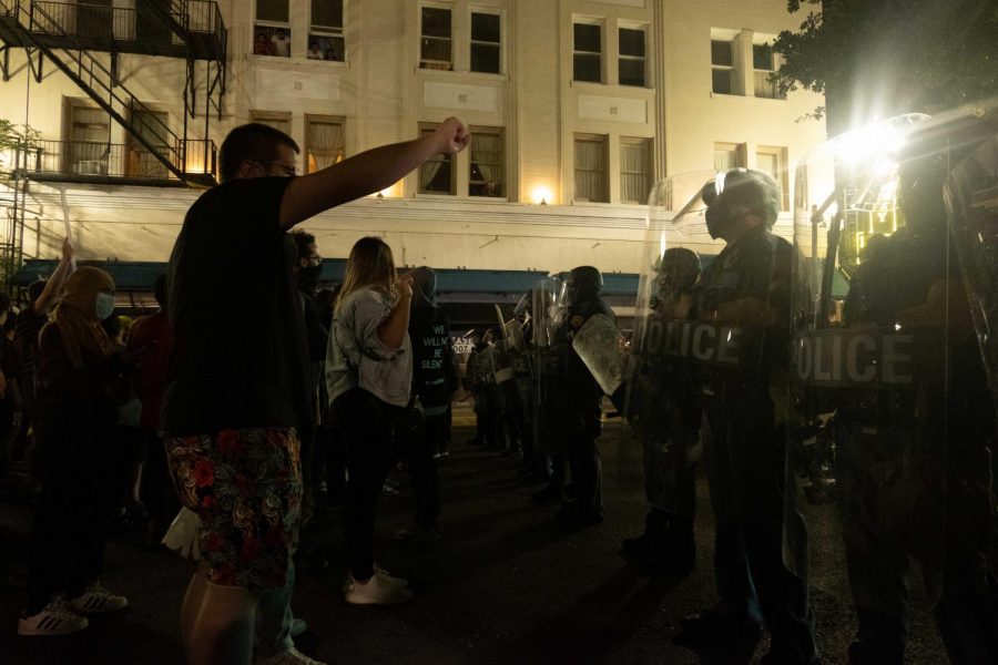 Protester raises hand in defiance to police line in protest June 2.