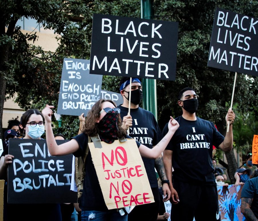  Protestors hold signs demanding justice for George Floyd and the end of police brutality at Aztec Calendar Park, June 2. 