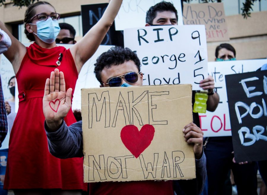 Protester holds up sign with message of make love not war at downtown rally June 2.