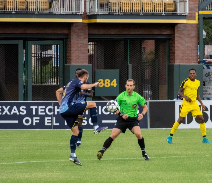 Locomotive midfielder Nick Ross controls pass from teammate as referee tries to clear a path versus New Mexico July 15, 2020.
