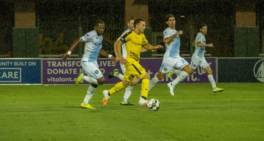 The Locomotive defense tries to chase down  an attacking  New Mexico player on  a rain drenched Southwest University Field July 24,2020