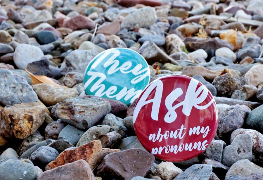Buttons promoting the normalization of asking individuals for their preferred pronouns across the gender spectrum. 
