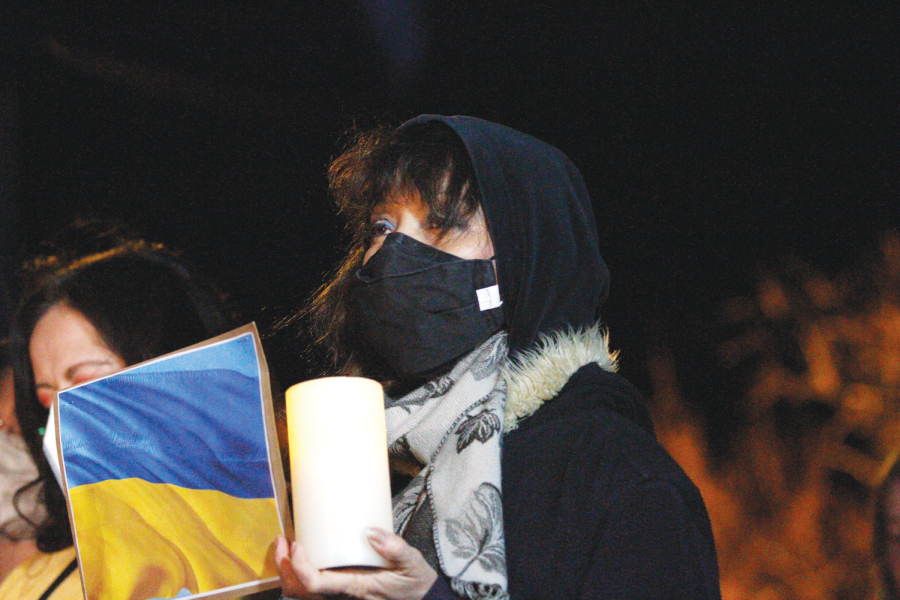 A woman holds a candle and a Ukranian flag during a prayer vigil for Ukraine at Tom Lea Park on Feb. 28. 