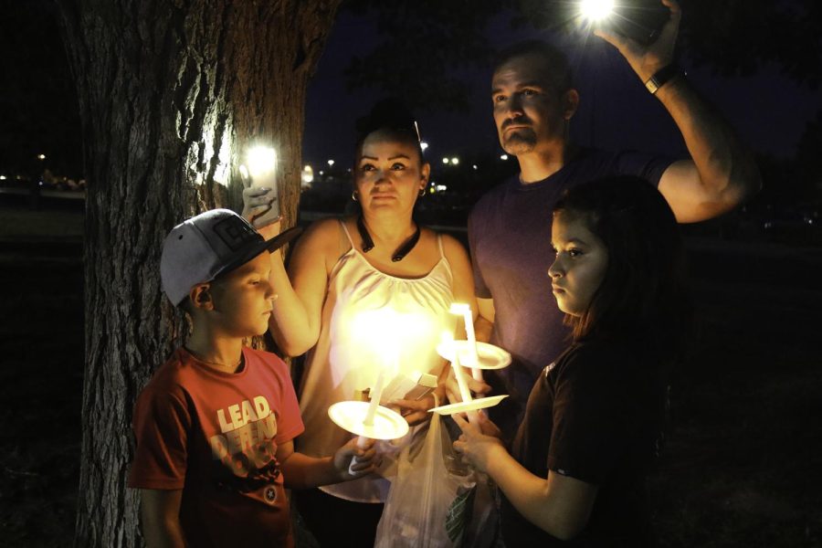 A family mourns at Ponder Park Aug. 4, 2019, after the shooting at a local Walmart that killed 23 people. 
