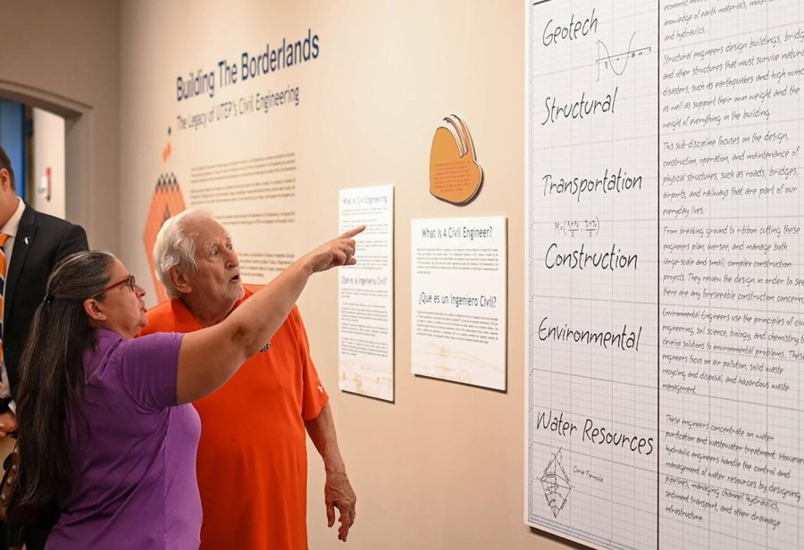 Attendees look upon and point out details of a piece on display as part of the Building the Borderlands exhibit.  