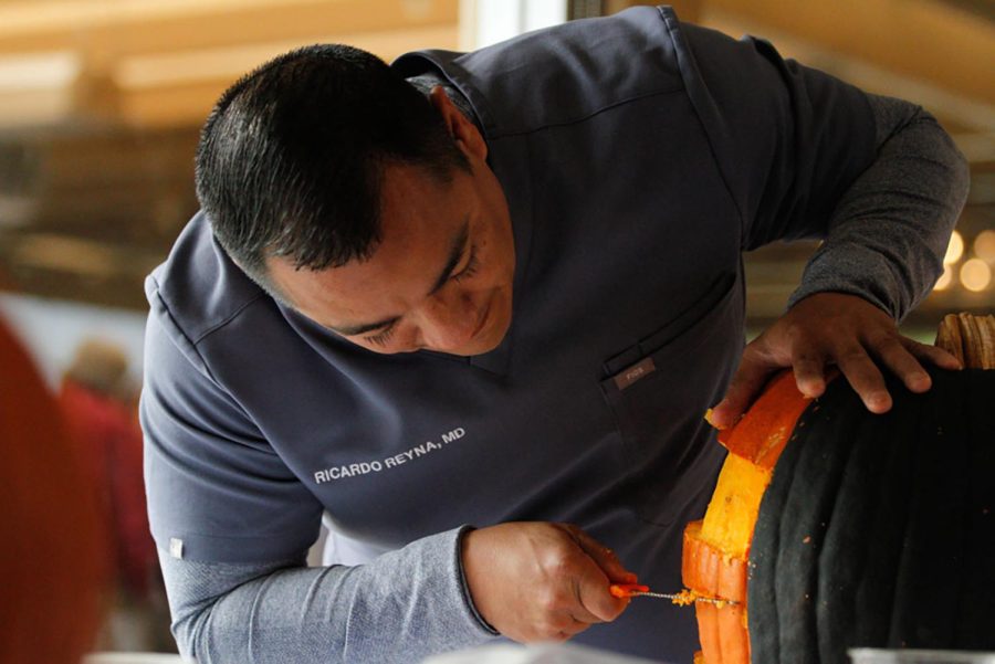 Dr. Ricardo Reyna begins carving the side of his pumpkin on Oct. 23 at the Coronado Country Club.