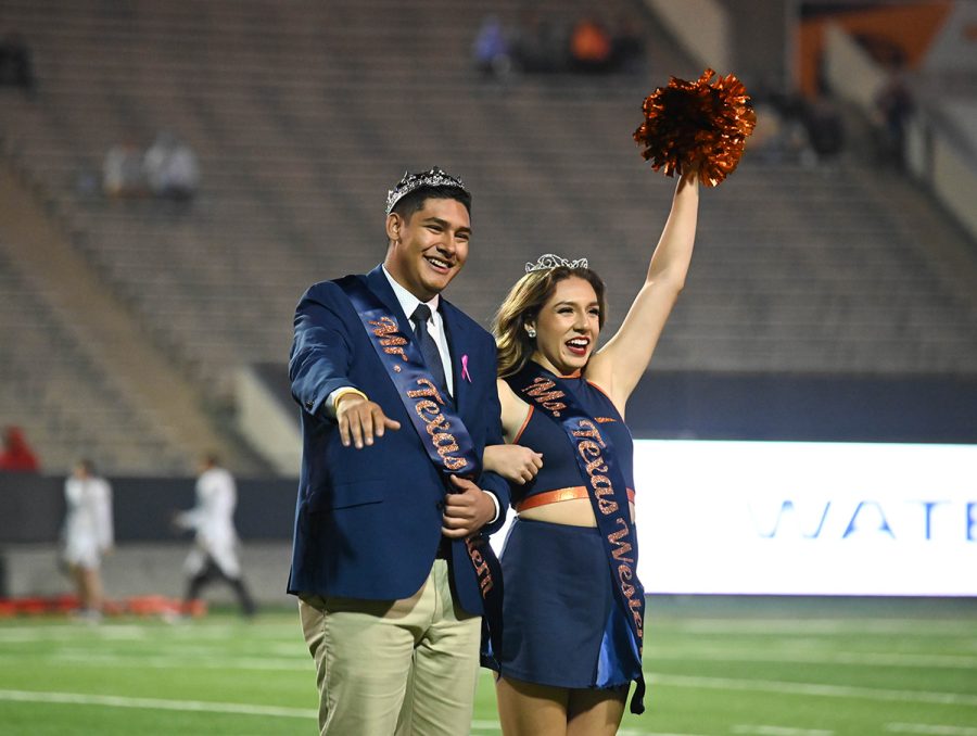 Mr. and Ms. Texas Western, multimedia journalism senior Lorenzo Leyva and kinesiology senior Kaitlyn Bradham, walk out to greet the crowd in attendance of the homecoming game on Oct. 29. 