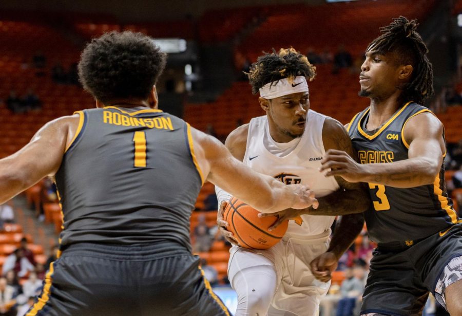 Guard Mario McKinney Jr. Plays offense as he passes two Aggies players to the basket.  