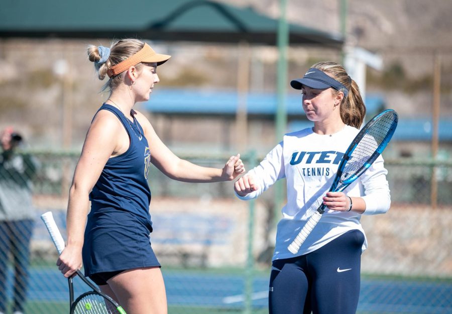 Senior Eve Daniels and sophomore Carlotta Mencagila give each other a fist pump during a break in play of a match against UTSA.  