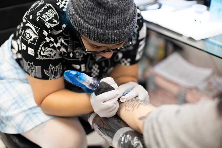 Artist Goldie Jones from The Good Life Tattoo works on a client.