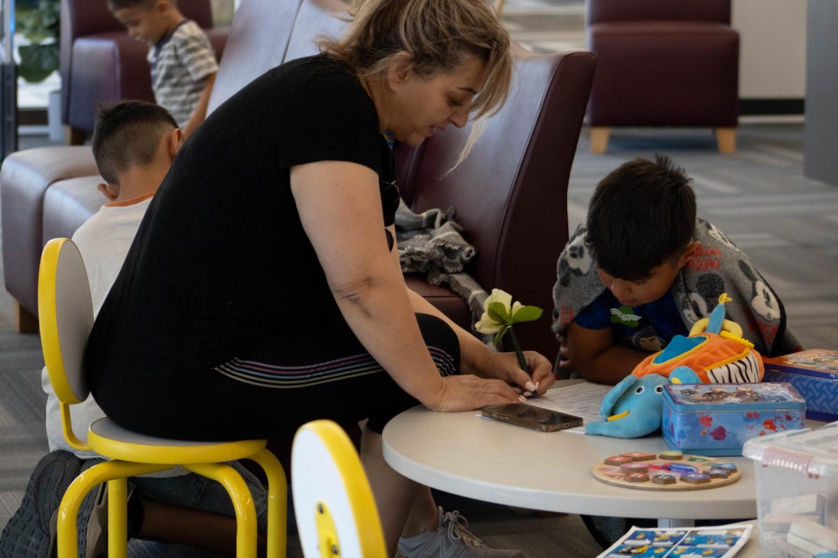 A mother helps her son to fill an application for the library member card.  