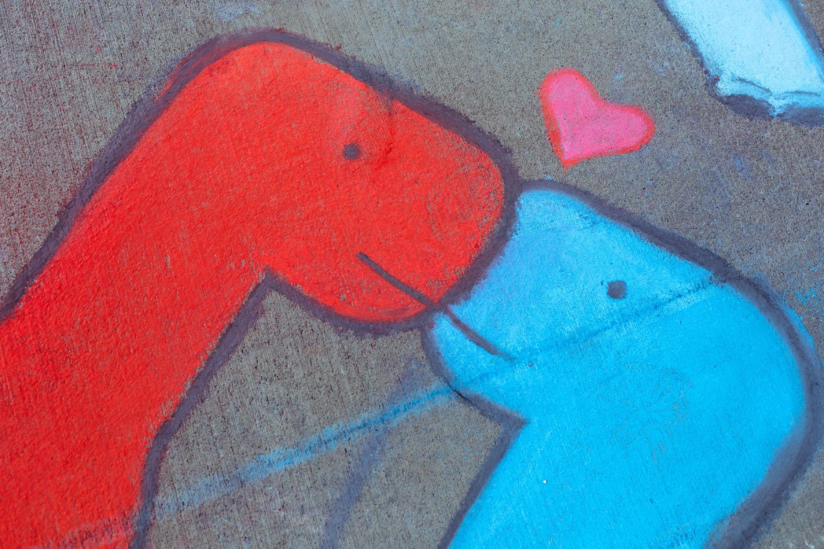 A chalk drawing of two dinosaurs kissing.  