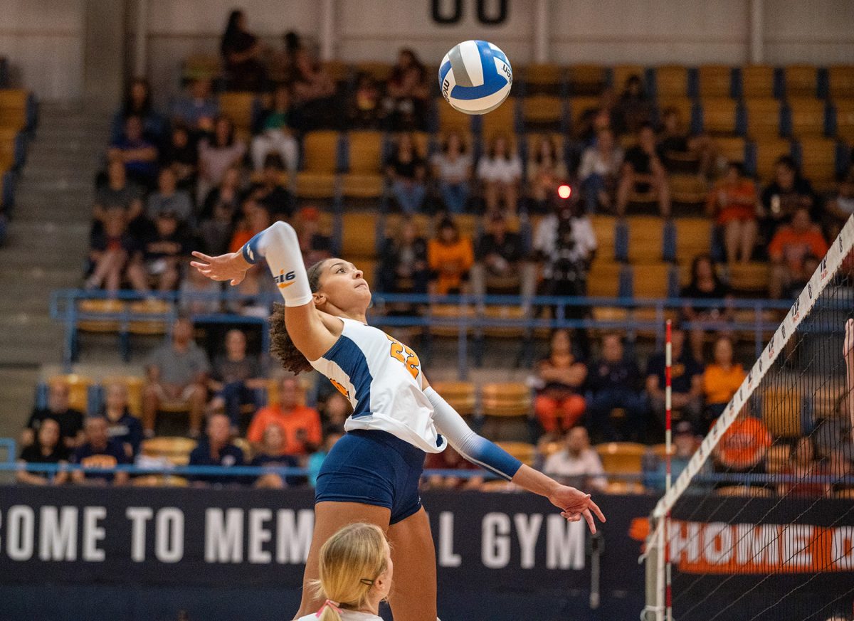 Middle blocker Danika Washington jumps up in the air to hit the ball during a set against Jacksonville State. 