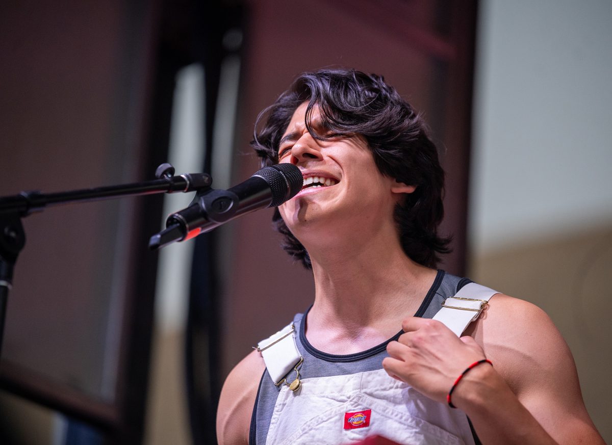 Artist from Sultanes del Yonke, sings into a microphone during a performance at Minerpalooza. 