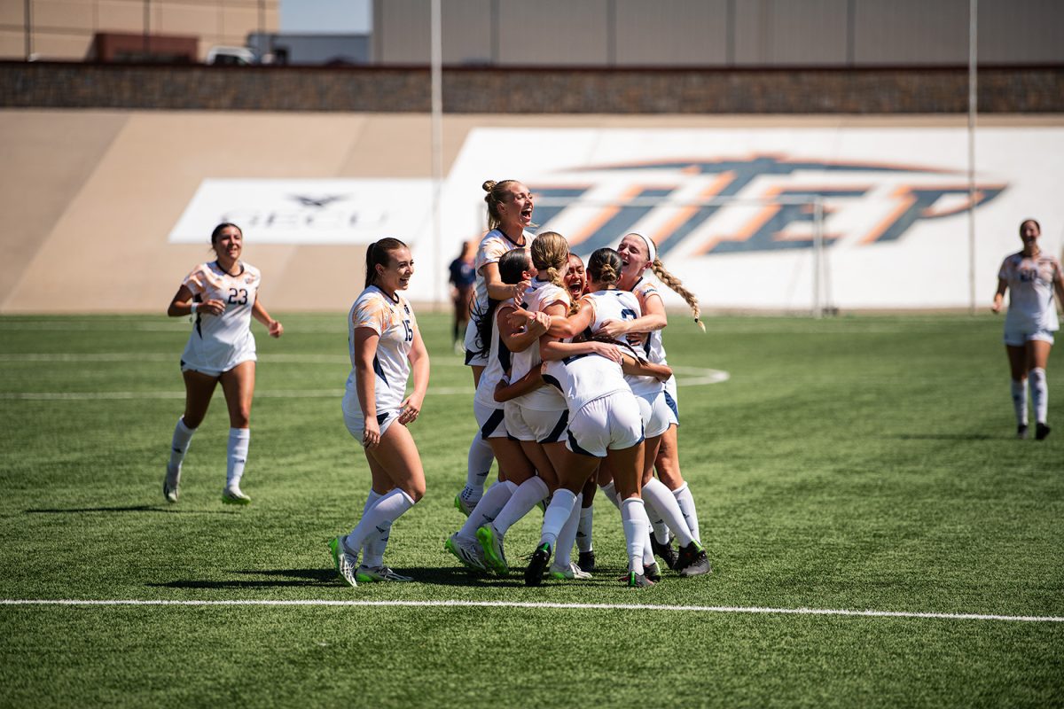Lady miners all go to hug Mina Rodriguez after her goal.