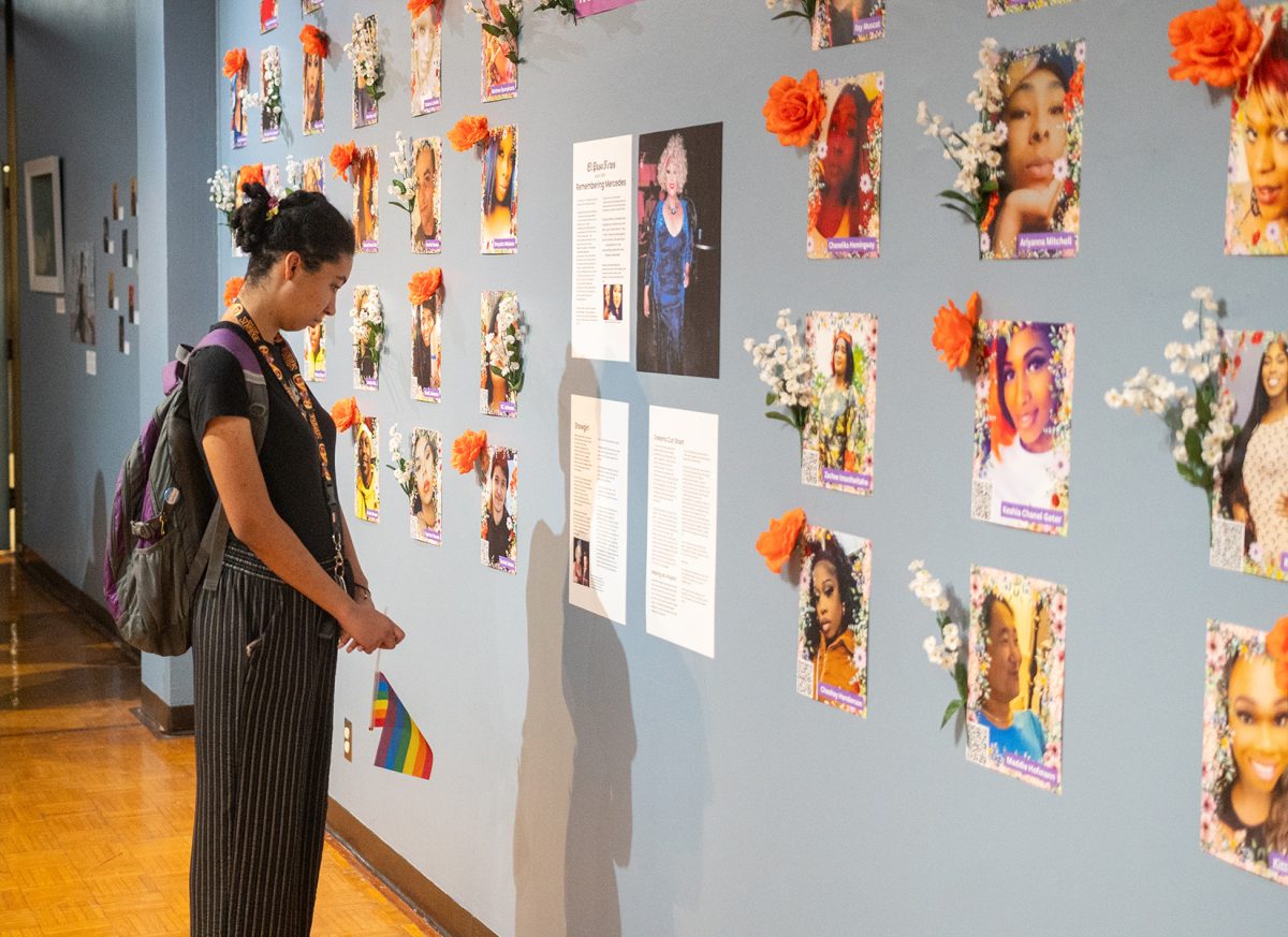 Attendee looks upon the art on display at the Queer History Month Gallery. 