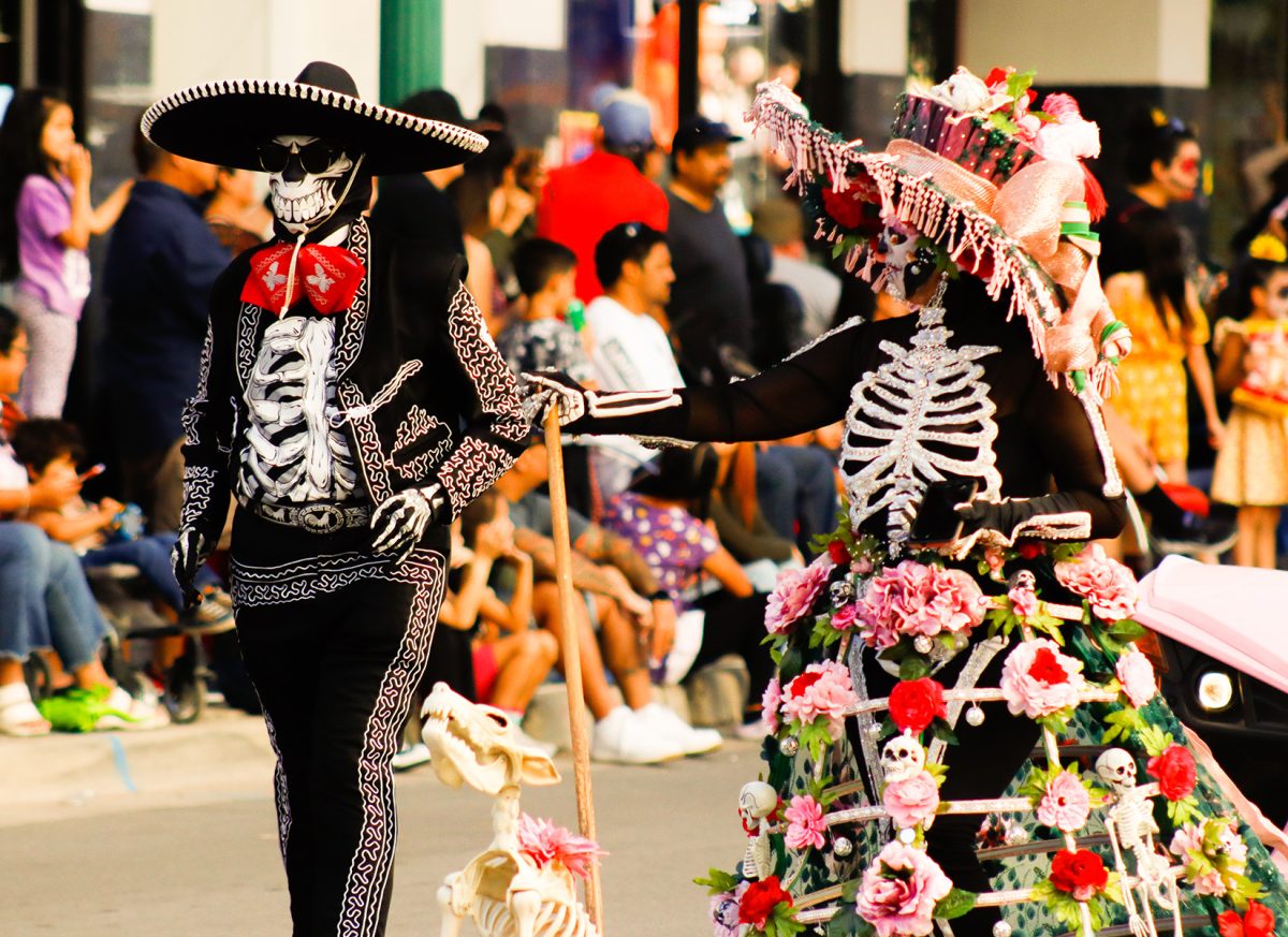 Skeleton Dis De Los Muertos couple with dog make an impression with their costumes. 
