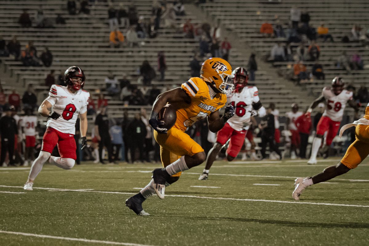 Running Back Torrance Burgess Jr. runs across the field after catching the ball. 