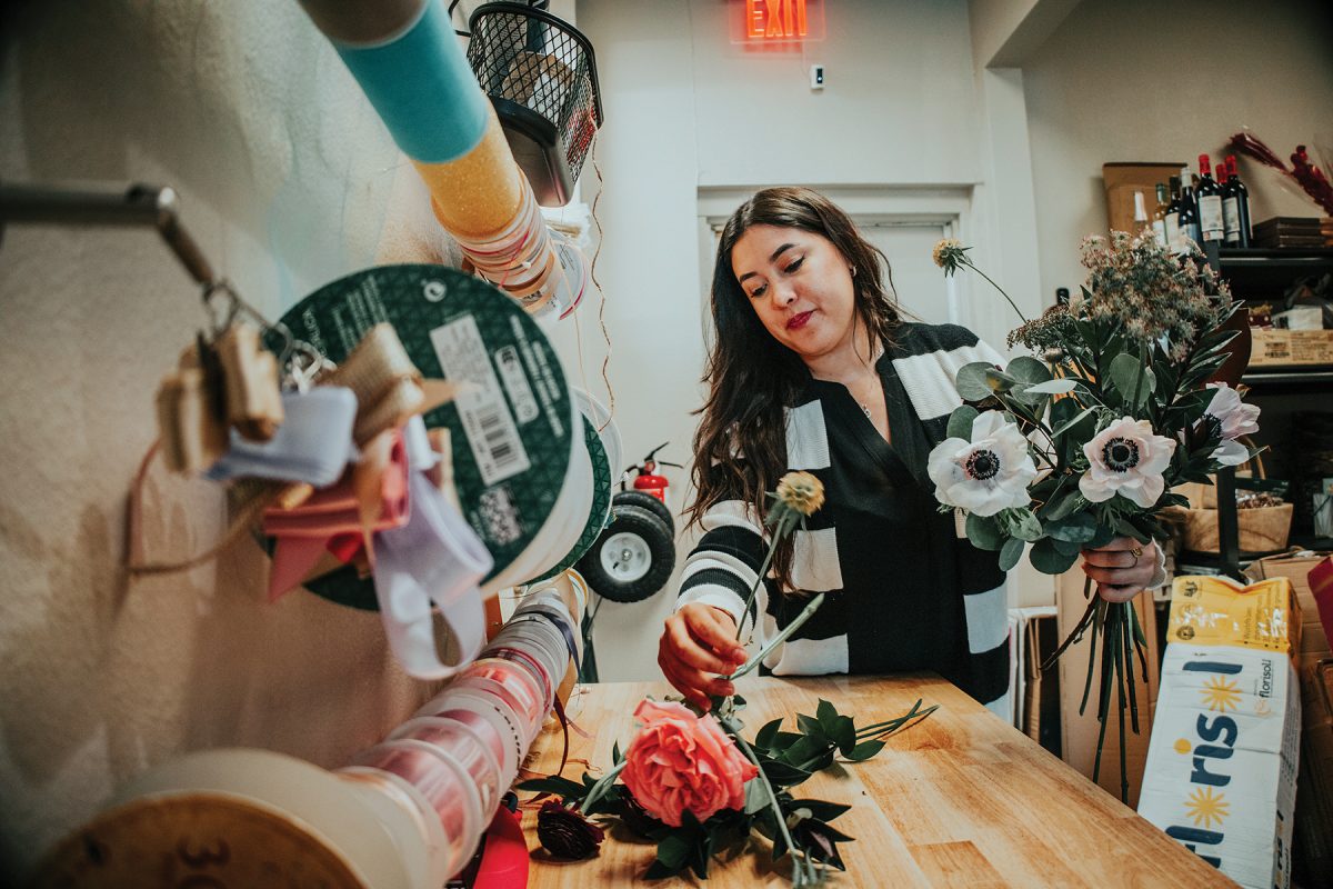 Loni Guillen arranges a bouquet which is a popular item sold during graduation season.