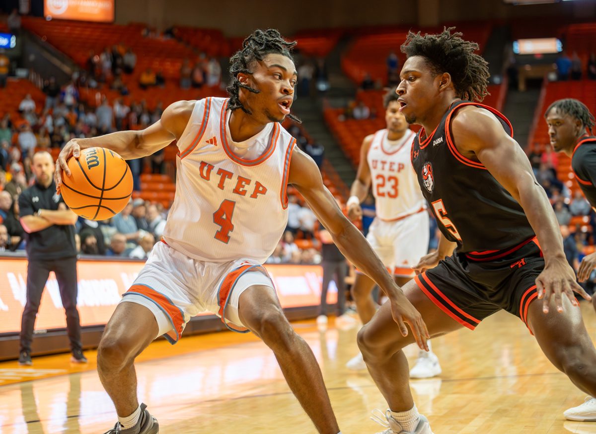 Guard Corey Camper Jr. dribbles the ball while being closely defended by a Sam Houston player, Feb. 24.  