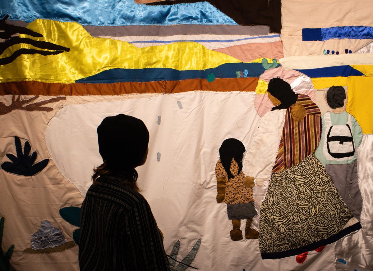 Guest admires “La Familia” tapestry at the Punto de Partida exhibit.