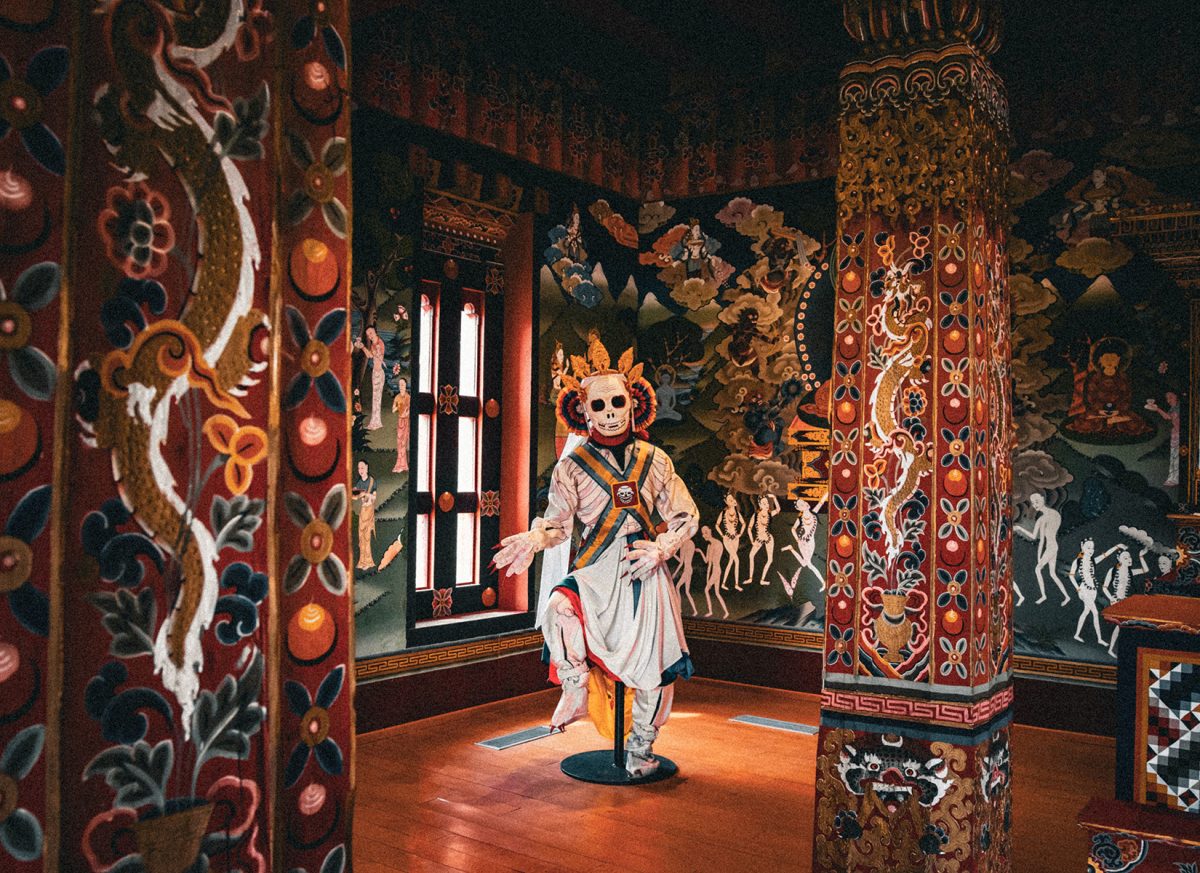 A traditional mask dancer figure, known as a cham performer, captures Bhutanese celebrations’ sacred and festive spirit.