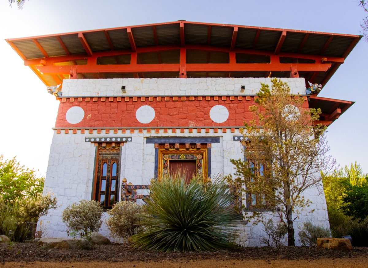 The rear side of the Lhakhang Temple showcases traditional Bhutanese design with its battered walls and colorful woodwork.