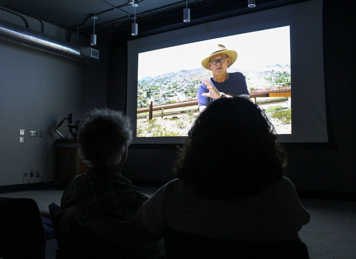 The projection of The Life of Brian (Maguire) illuminates the screen as two audience members watch the movie during the public screening at UTEP’s Stanlee and Gerald Rubin Center for the Visual Arts. 
