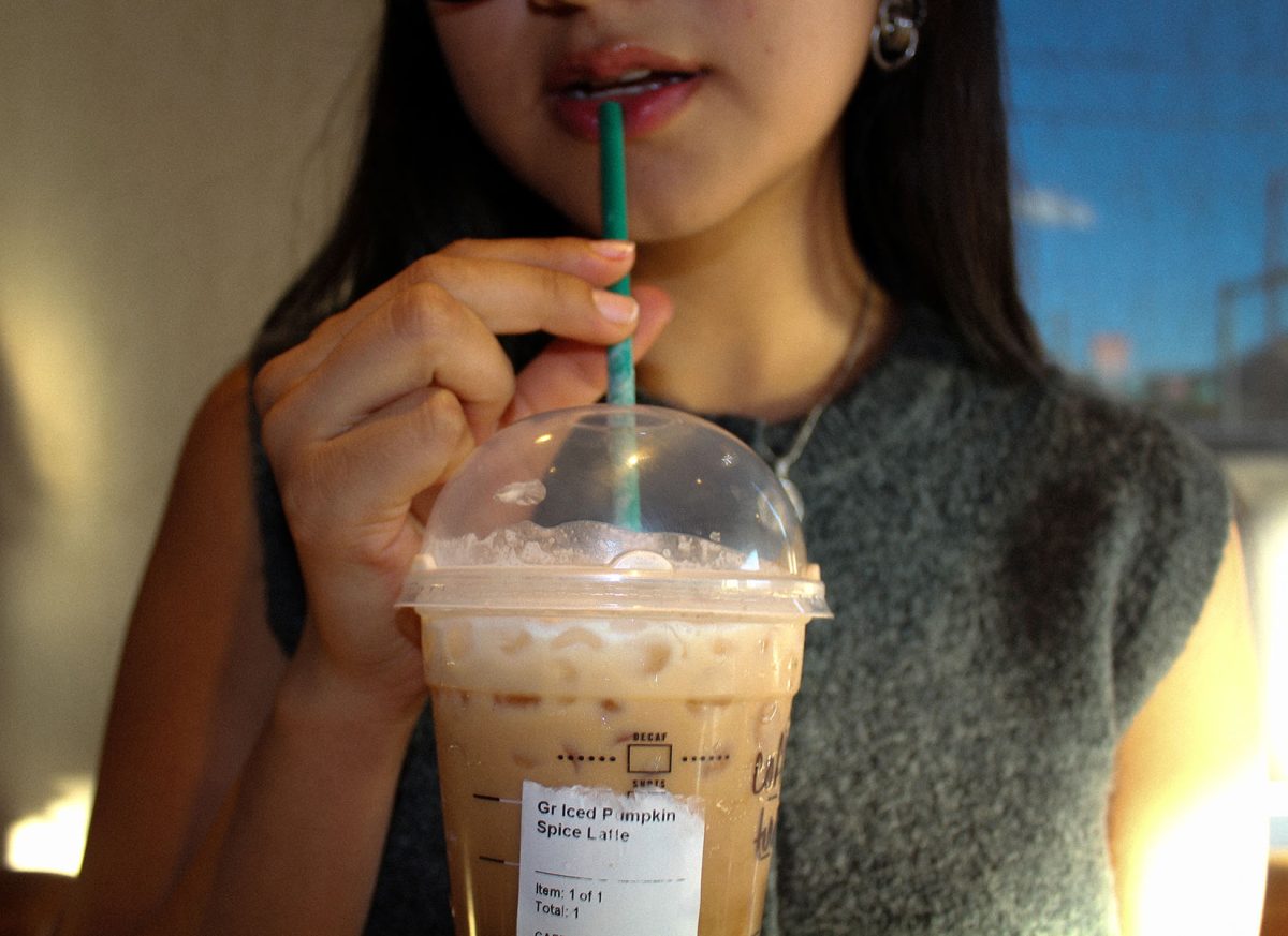 Iced pumpkin spice latte in hand, a coffee drinker shows off the flavor that has become a synonym for autumn.