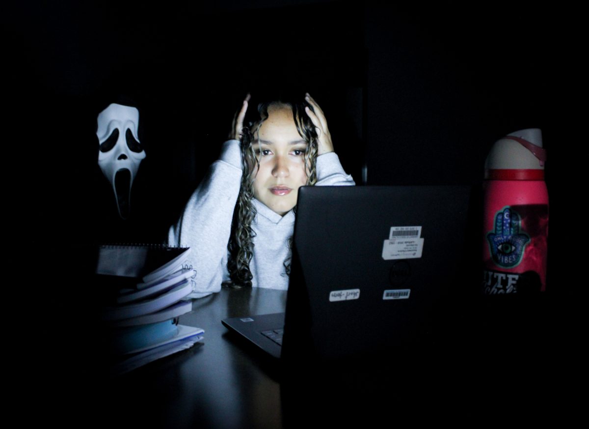 The student, Melina Holguin, is being haunted by the person in the mask, representing the academic stress she is going through.