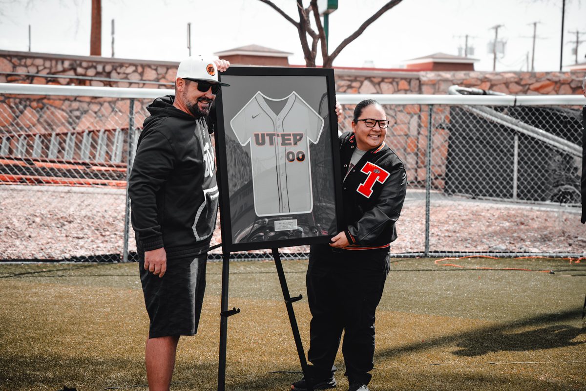 UTEP Softball head coach T.J. Hubbard, presents Chelsea Troupe with a framed jersey in honor of her jersey retirement. 